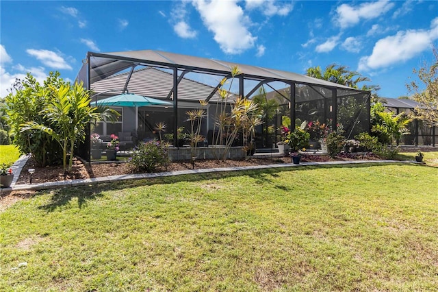 rear view of property with a yard and glass enclosure