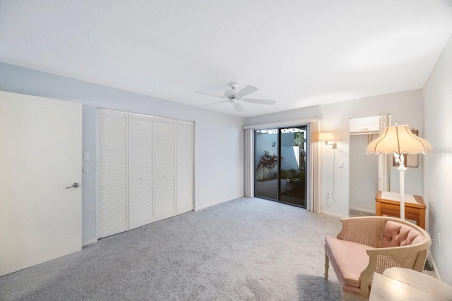 sitting room featuring ceiling fan, carpet, and a wall unit AC