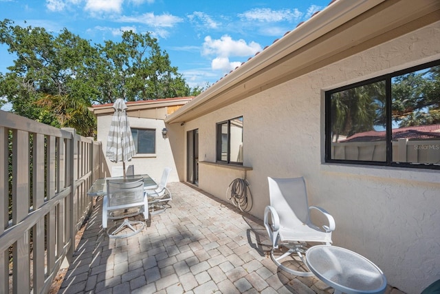 view of patio with outdoor dining space and fence