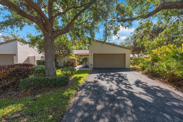 view of front facade with aphalt driveway, stucco siding, and a garage