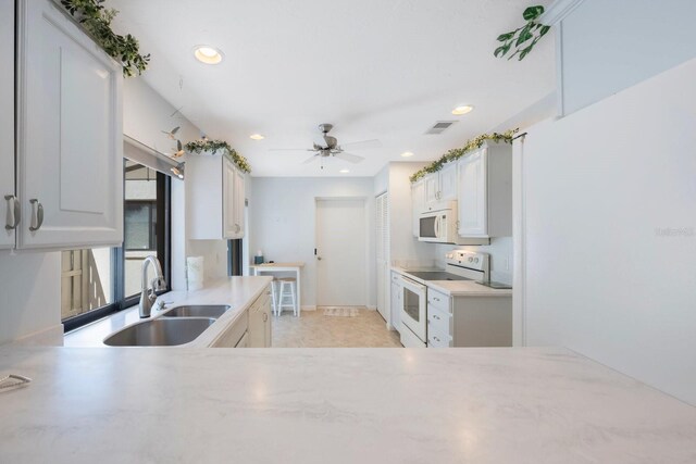kitchen with white appliances, a ceiling fan, visible vents, recessed lighting, and a sink
