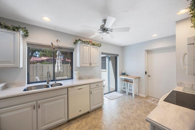 kitchen featuring a sink, light countertops, ceiling fan, white appliances, and recessed lighting