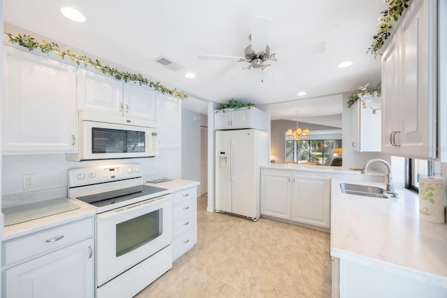 kitchen with white cabinets, white appliances, visible vents, and a sink
