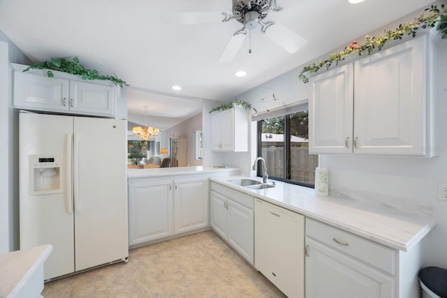kitchen featuring white cabinets, a sink, light countertops, white appliances, and recessed lighting
