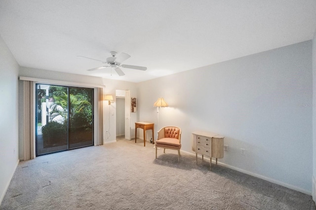 living area with carpet flooring, baseboards, and a ceiling fan