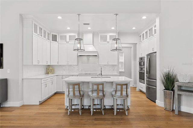 4013 Red Rock Ln, Sarasota, FL 34231 - kitchen with stainless steel appliances, a kitchen island with sink, light countertops, decorative backsplash, and baseboards