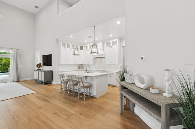 4013 Red Rock Ln, Sarasota, FL 34231 - kitchen featuring a sink, light countertops, a kitchen island with sink, a kitchen breakfast bar, and light wood-style floors
