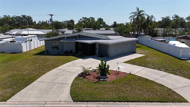 5727 25th St W, Bradenton, FL 34207 - view of front of property featuring a front yard, an attached garage, fence, and driveway