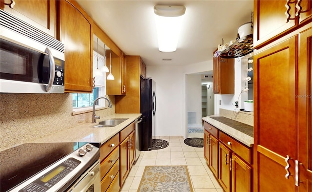 5727 25th St W, Bradenton, FL 34207 - kitchen featuring visible vents, light tile patterned floors, a sink, stainless steel appliances, and backsplash
