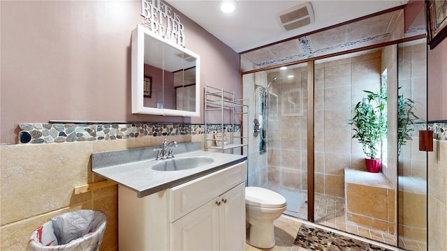 5727 25th St W, Bradenton, FL 34207 - full bathroom featuring visible vents, toilet, tile walls, vanity, and a stall shower