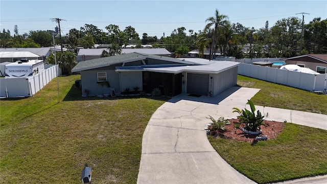 5727 25th St W, Bradenton, FL 34207 - view of front of home with an attached garage, concrete driveway, a front yard, and fence