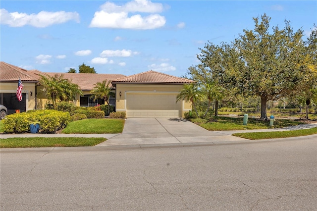 2064 Batello Dr, Venice, FL 34292 - view of front of house with a garage, driveway, a tiled roof, and stucco siding