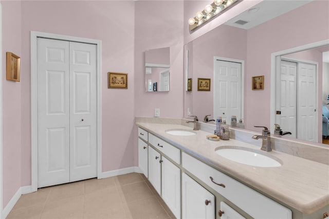 2064 Batello Dr, Venice, FL 34292 - bathroom with a closet, double vanity, tile patterned flooring, and baseboards