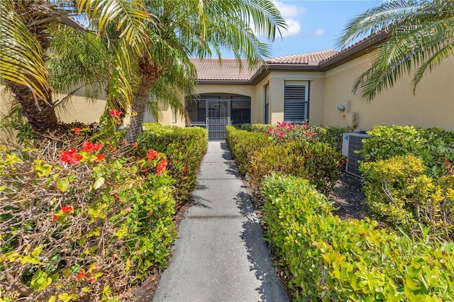 2064 Batello Dr, Venice, FL 34292 - view of exterior entry with stucco siding, a tile roof, and central air condition unit