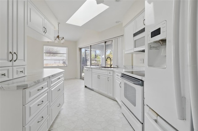 23116 Amethyst Ave, Port Charlotte, FL 33952 - kitchen featuring a skylight, light stone countertops, a sink, white appliances, and white cabinetry