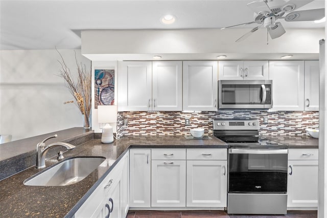 1233 Dockside Pl Unit 207, Sarasota, FL 34242 - kitchen with stainless steel appliances, a sink, a ceiling fan, white cabinets, and backsplash