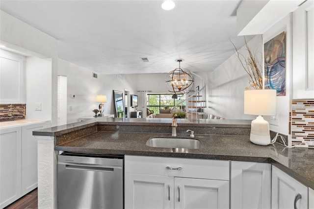 1233 Dockside Pl Unit 207, Sarasota, FL 34242 - kitchen featuring stainless steel dishwasher, a sink, backsplash, open floor plan, and white cabinetry