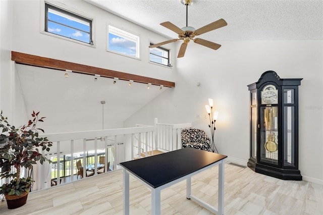 1233 Dockside Pl Unit 207, Sarasota, FL 34242 - interior space featuring a ceiling fan, high vaulted ceiling, plenty of natural light, a textured ceiling, and rail lighting