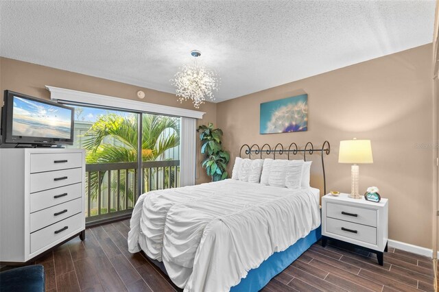 1233 Dockside Pl Unit 207, Sarasota, FL 34242 - bedroom featuring wood tiled floors, a chandelier, access to exterior, a textured ceiling, and baseboards
