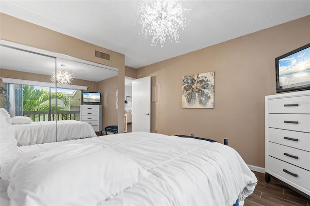 1233 Dockside Pl Unit 207, Sarasota, FL 34242 - bedroom featuring dark wood-style flooring, baseboards, a chandelier, and access to outside