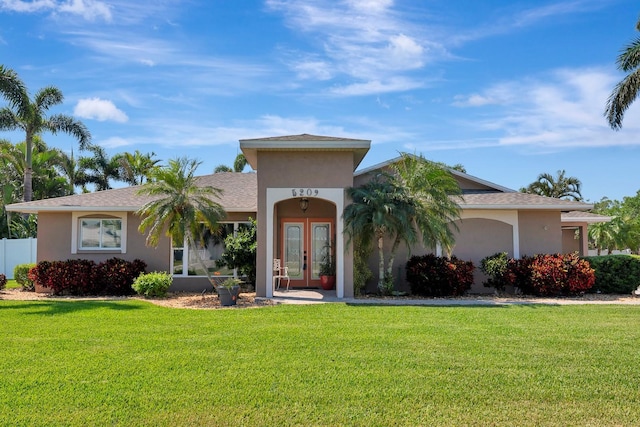 5209 26th Ave W, Bradenton, FL 34209 - view of front facade with french doors, a front lawn, and stucco siding