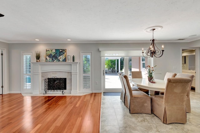 5209 26th Ave W, Bradenton, FL 34209 - dining area featuring a tiled fireplace, healthy amount of natural light, ornamental molding, a chandelier, and recessed lighting