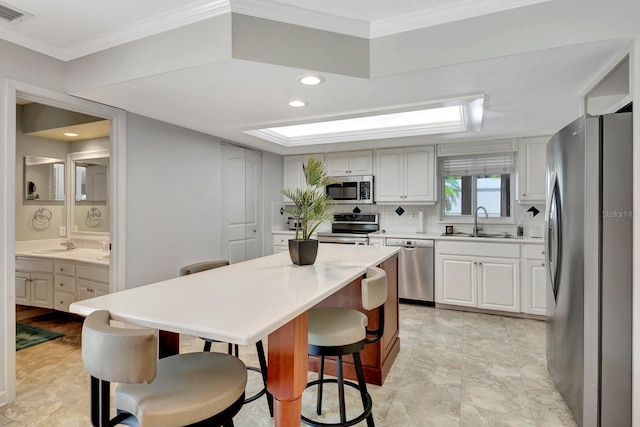 5209 26th Ave W, Bradenton, FL 34209 - kitchen featuring stainless steel appliances, a sink, a kitchen bar, light countertops, and backsplash