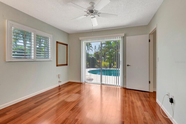 5209 26th Ave W, Bradenton, FL 34209 - empty room with a ceiling fan, a textured ceiling, wood finished floors, and baseboards