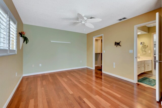 5209 26th Ave W, Bradenton, FL 34209 - unfurnished bedroom featuring wood finished floors, a spacious closet, baseboards, ceiling fan, and a closet