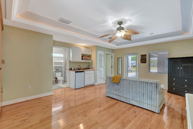 5209 26th Ave W, Bradenton, FL 34209 - unfurnished living room featuring a raised ceiling, a sink, a ceiling fan, and light wood-style flooring