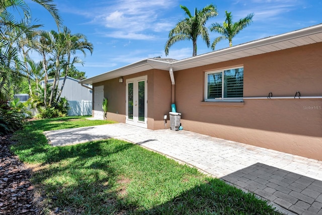 5209 26th Ave W, Bradenton, FL 34209 - back of property with french doors, stucco siding, a yard, and a patio area