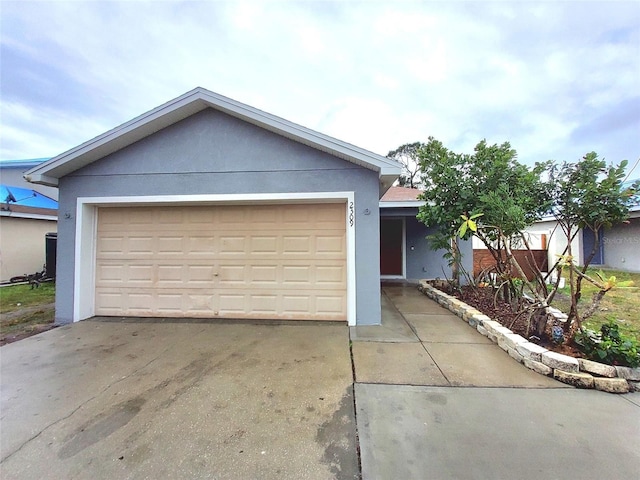 single story home featuring stucco siding, driveway, and a garage