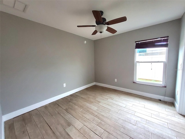 spare room featuring baseboards, ceiling fan, visible vents, and light wood-type flooring