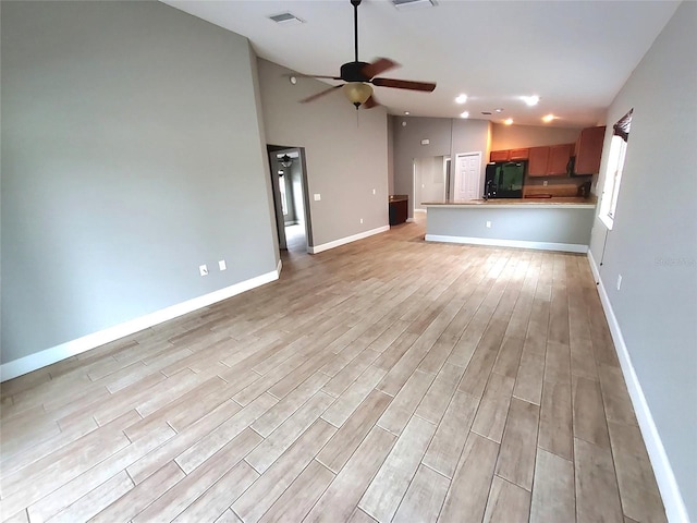 unfurnished living room featuring lofted ceiling, baseboards, light wood finished floors, ceiling fan, and visible vents