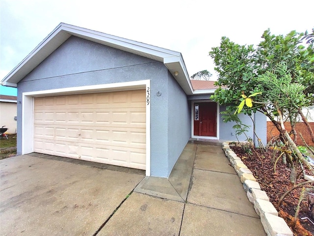 exterior space featuring driveway, stucco siding, and an attached garage