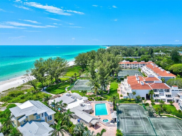 aerial view of waterfront with a beach and a pool area