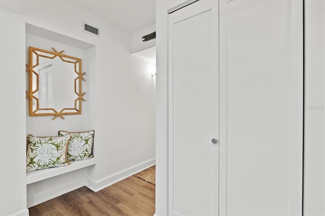 hallway with wood finished floors and baseboards
