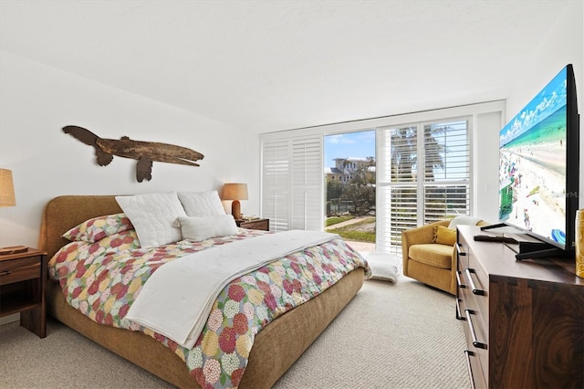 bedroom featuring light colored carpet and access to outside