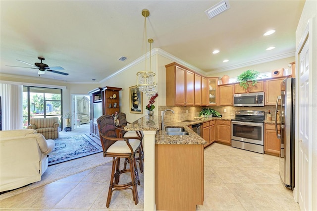 19889 Benissimo Dr, Venice, FL 34293 - kitchen with light stone counters, a kitchen bar, a peninsula, open floor plan, and stainless steel appliances