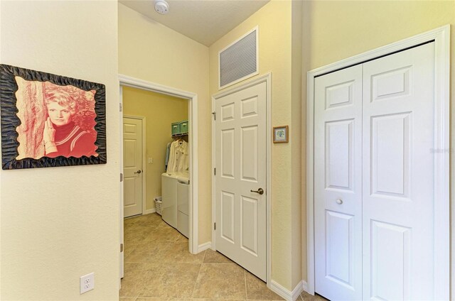 19889 Benissimo Dr, Venice, FL 34293 - corridor with baseboards, light tile patterned flooring, visible vents, and washer and dryer