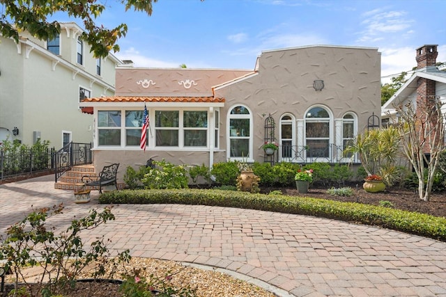 rear view of property featuring stucco siding and a tiled roof