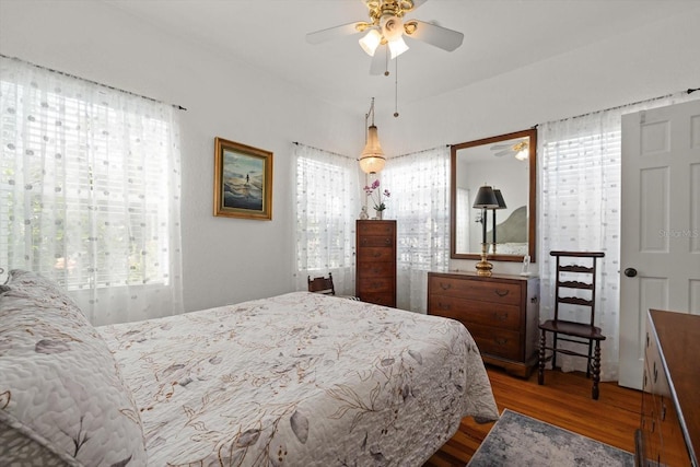 bedroom with multiple windows and wood finished floors
