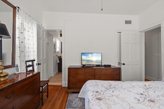 bedroom featuring wood finished floors and visible vents