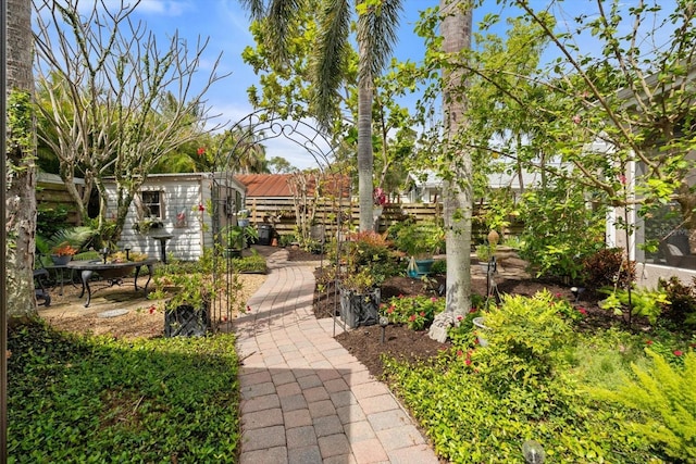 view of home's community featuring a patio area, an outbuilding, fence, and a storage shed
