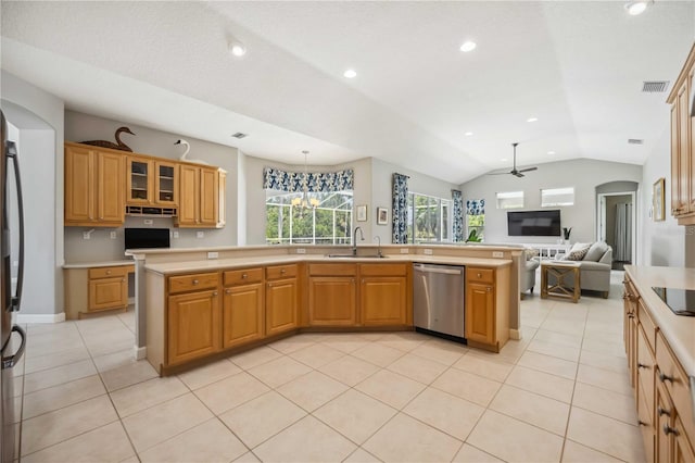kitchen featuring a sink, light countertops, arched walkways, stainless steel appliances, and vaulted ceiling