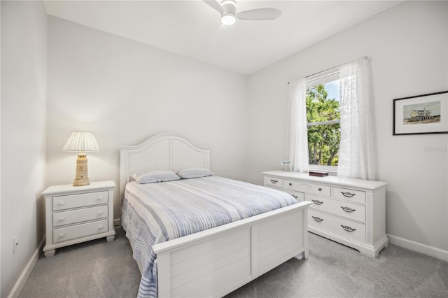 bedroom with a ceiling fan, baseboards, and light colored carpet