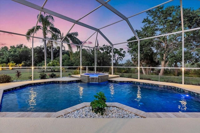 pool at dusk with glass enclosure, a patio area, and a pool with connected hot tub