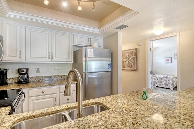5963 Midnight Pass Rd Unit 355, Sarasota, FL 34242 - kitchen featuring freestanding refrigerator, a sink, a raised ceiling, white cabinetry, and ornamental molding