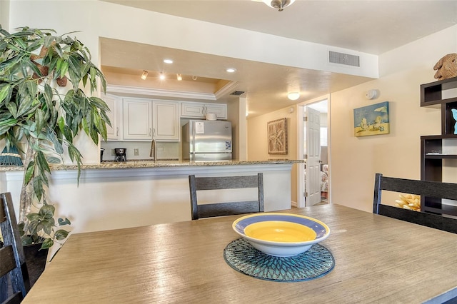 5963 Midnight Pass Rd Unit 355, Sarasota, FL 34242 - dining room featuring a tray ceiling, wood finished floors, and ornamental molding
