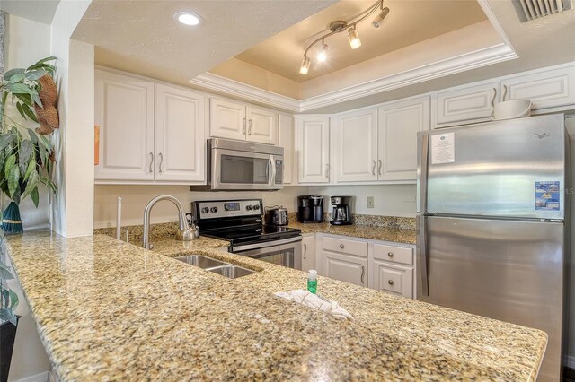5963 Midnight Pass Rd Unit 355, Sarasota, FL 34242 - kitchen featuring appliances with stainless steel finishes, a raised ceiling, white cabinetry, and light stone counters